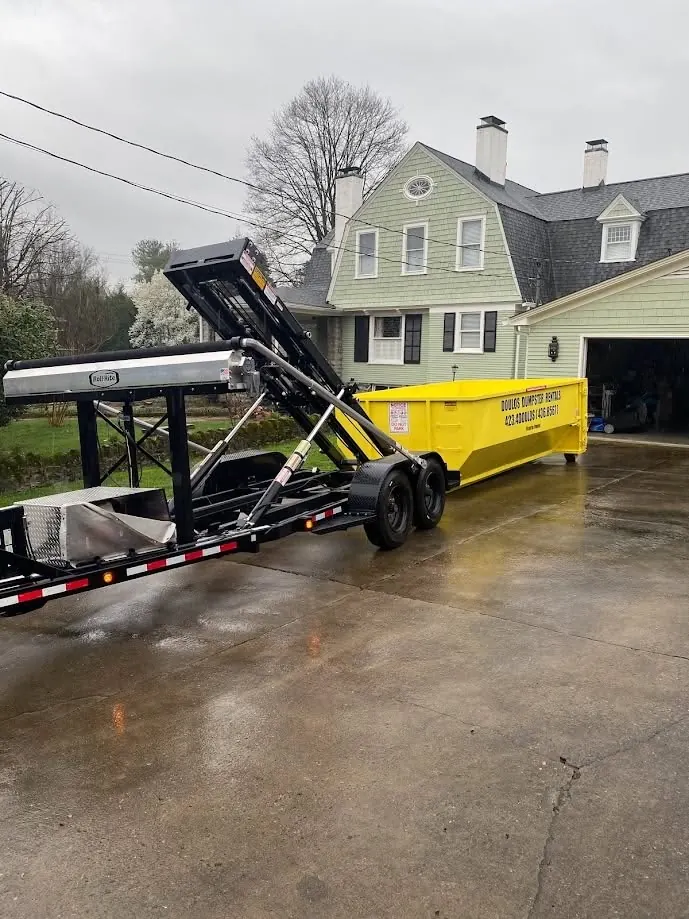 Doulos truck delivering a container on a hooklift trailer